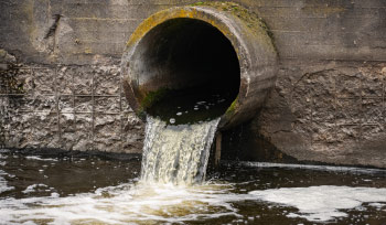 Water Pouring Out Of A Pipe In A Wall